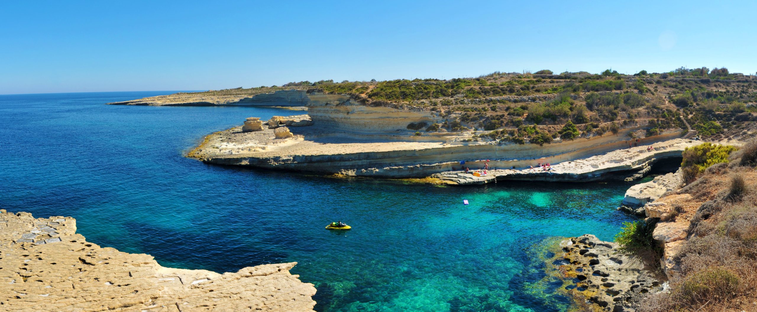 St Peter’s Pool rocky coastline with clear blue water in the south of Malta